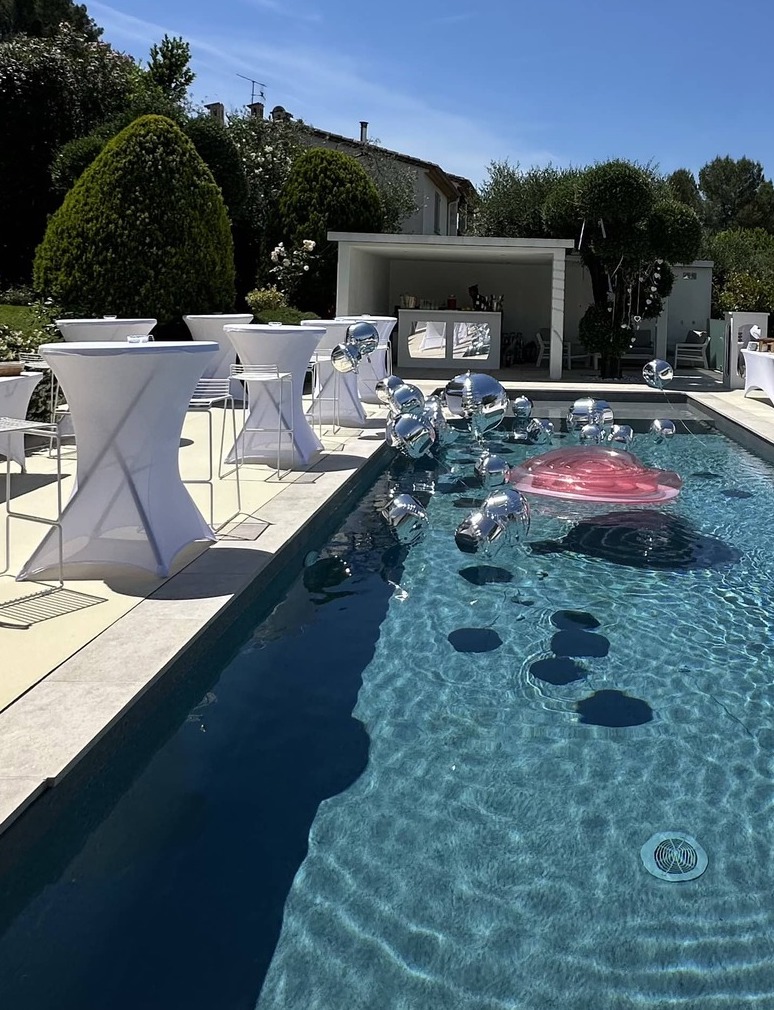 Location bar événementiel avec éléments décoratifs miroir et tables mange-debout blanches, installé en bord de piscine, idéal pour cocktails et événements haut de gamme sur la Côte d’Azur Agence évènementielle loueur de mobilier