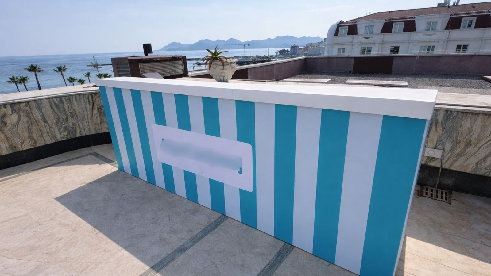 Bar événementiel avec bâche imprimée personnalisée aux couleurs et logo du client, installé en extérieur avec vue mer, idéal pour événements corporate et réceptions sur la Côte d’Azur Agence évènementielle location de mobilier